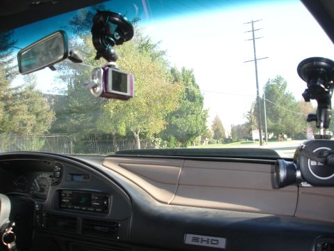 1993 Ford Taurus - Interior view of a vehicle's dashboard, showing multiple camera mounts and a digital camera attached to the windshield.