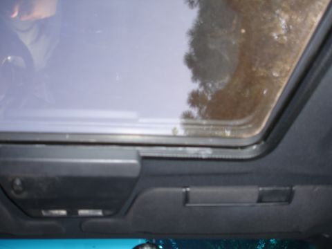 1993 Ford Taurus - Car interior showing sunroof and overhead console; reflection of trees visible in sunroof glass.
