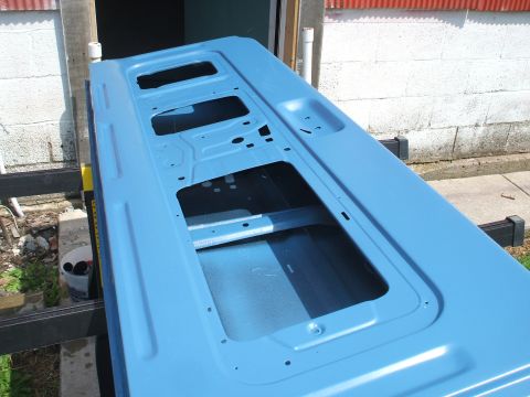 1990 Ford Bronco - Car door painted light blue, showing interior structure and mounting points.
