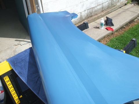 1990 Ford Bronco - A blue car fender rests on sawhorses, ready for work.