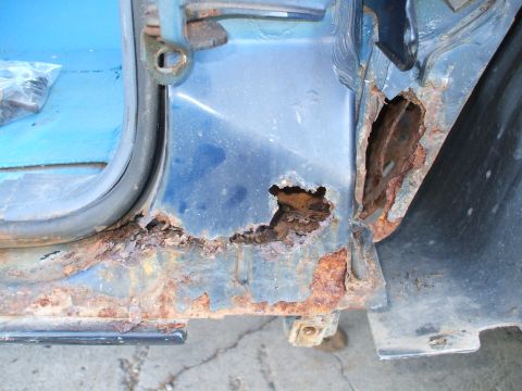 1990 Ford Bronco - Severe rust damage on the door frame of a vehicle, obscuring the model year.