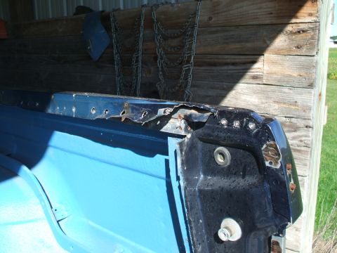 1990 Ford Bronco - A close-up view of a damaged and rusted vehicle body panel, showing signs of wear and tear.