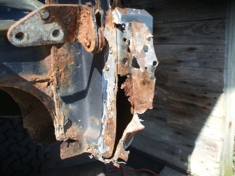 1990 Ford Bronco - This heavily rusted vehicle frame section shows significant corrosion and damage.
