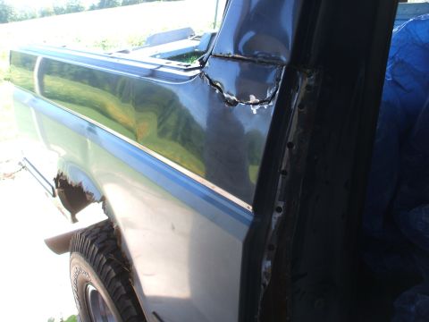 1990 Ford Bronco - This photo shows the rear side panel of a Ford Bronco, highlighting areas of rust and recent body repair work.