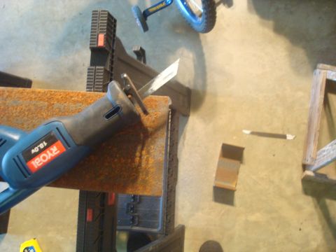 1995 Ford Bronco - A blue Ryobi reciprocating saw rests on a rusty metal surface, with a bicycle wheel visible in the background.