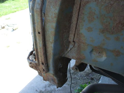 1990 Ford Bronco - Close-up of a heavily rusted vehicle fender well, showing structural details.