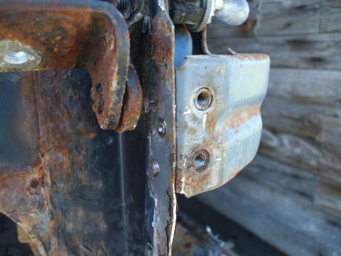 1990 Ford Bronco - Close-up of heavily rusted metal bracket and bolts, with the Supermotors.net logo in the lower right corner.