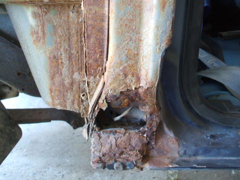 1990 Ford Bronco - The lower body panel of this vehicle is severely corroded, indicating extensive rust damage.