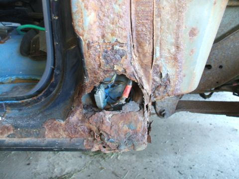 1990 Ford Bronco - Severe rust damage to the door frame reveals exposed wiring and a blue electrical connector.