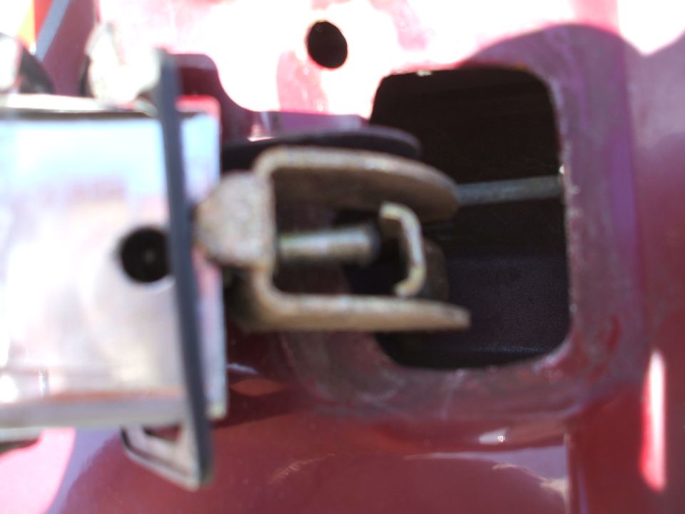 Close-up of a car's door latch mechanism, showing the metal components and linkage