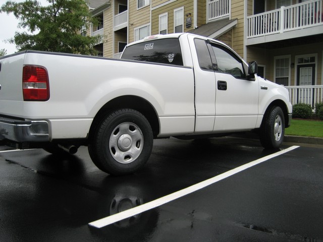 2004 Ford F-150 pickup truck parked on wet asphalt