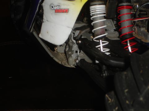 1989 Ford Bronco - Detail of a remote control car's suspension system, dual shocks and visible 'Opti DRIVE' text.