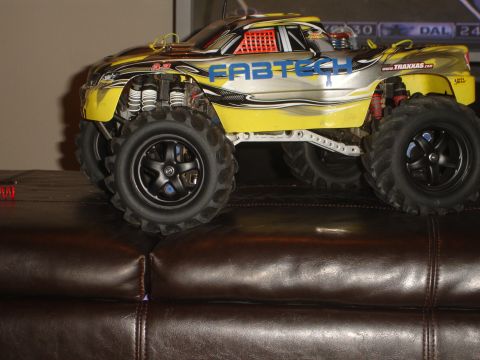 1989 Ford Bronco - This remote control monster truck features large off-road tires and a yellow and silver body with racing decals.