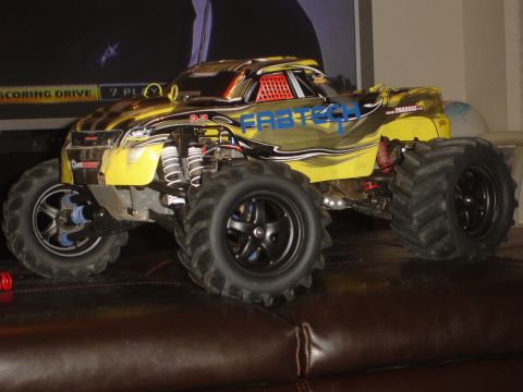 1989 Ford Bronco - A remote control monster truck with large tires and suspension is displayed on a brown surface.
