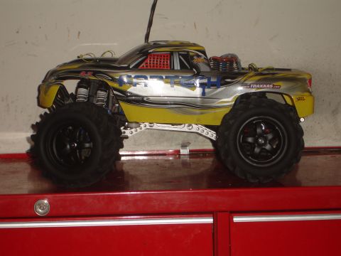 1989 Ford Bronco - This remote control monster truck is yellow and silver with racing decals and large off-road tires.