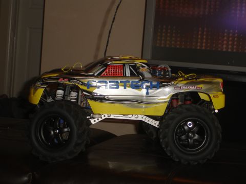 1989 Ford Bronco - This remote control monster truck features a yellow and silver body with "FASTTECH" branding and oversized off-road tires.