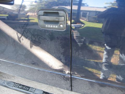 2005 Ford F-150 - Side view of a dark blue truck door a keypad entry system and visible scratches.