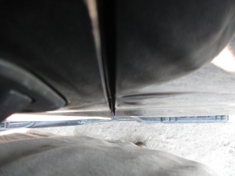 2005 Ford F-150 - Gap between truck doors, showing the lower trim piece and concrete ground.