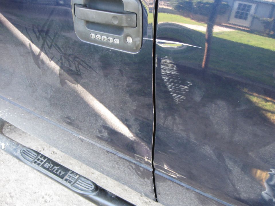 Dark blue 2005 Ford F-150 truck door with keypad entry and significant scratches