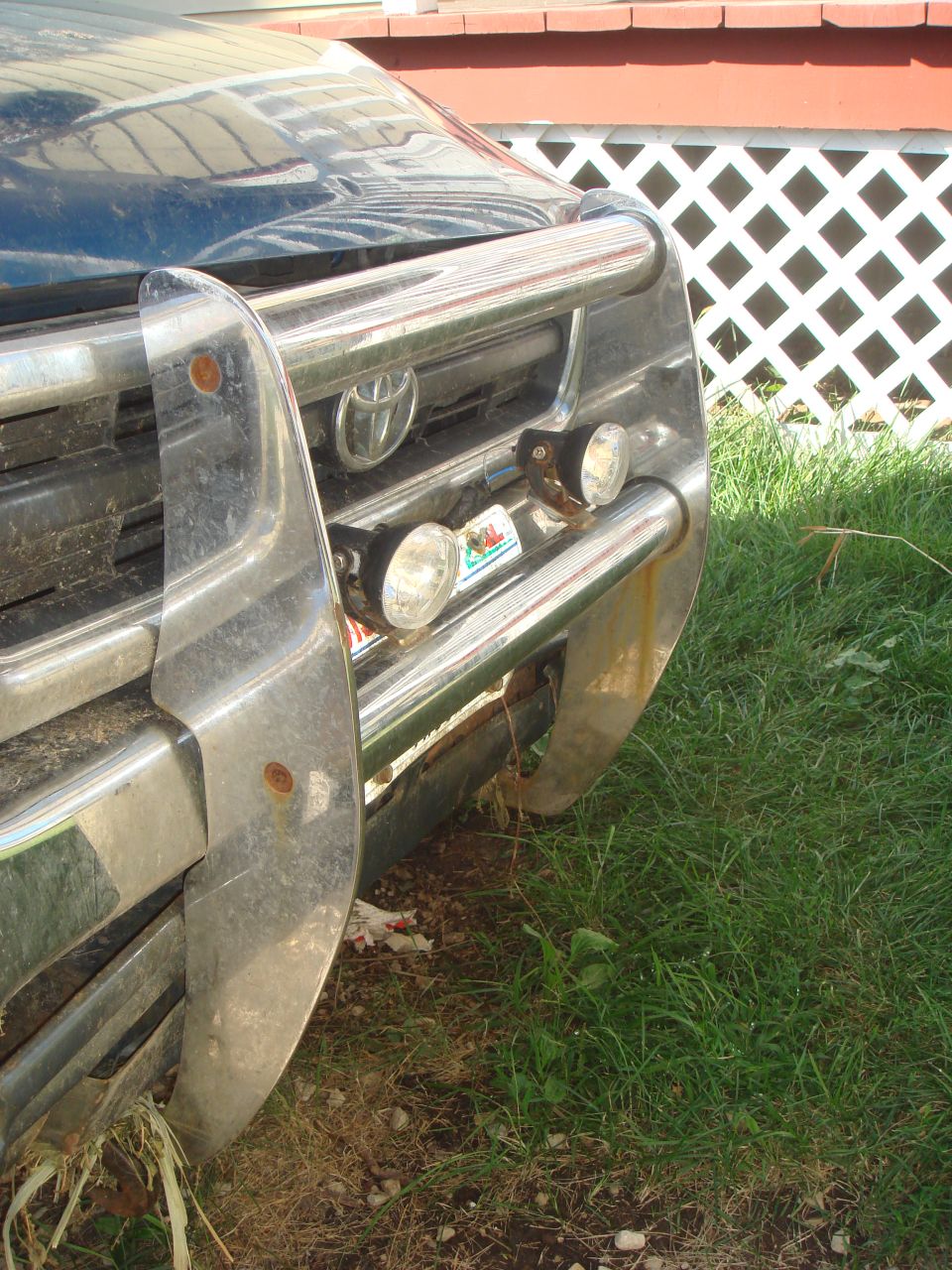 Front grille of a Toyota truck with a chrome bull bar and two fog lights. A "Super Motors" watermark is visible at the bottom right