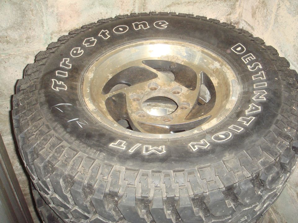 Close-up of a Firestone Destination M/T tire on a dirty alloy wheel