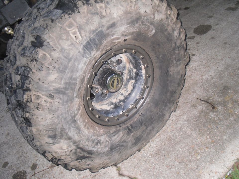 Close-up of a muddy off-road tire and beadlock wheel