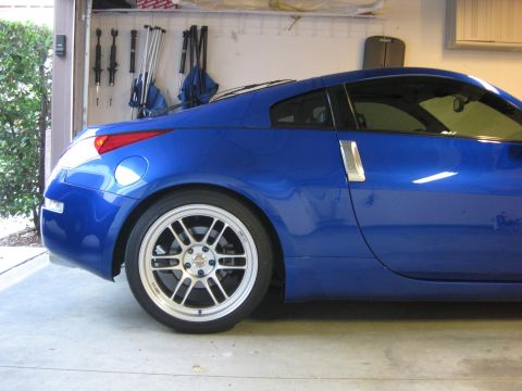 1990 Ford Probe - A blue sports coupe is parked in a garage, showing its side profile and aftermarket wheels.