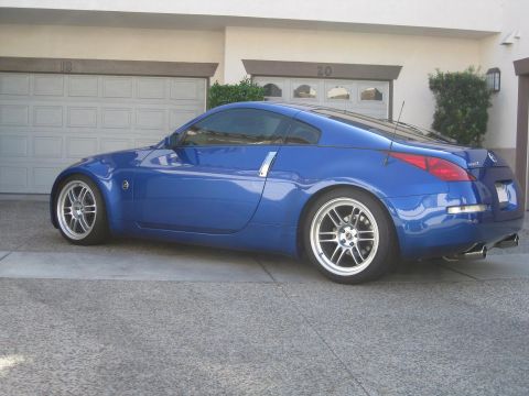 1990 Ford Probe - A blue coupe is parked in front of a residential garage with the doors closed.