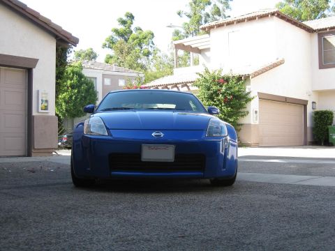 1990 Ford Probe - Front view of a blue Nissan 350Z parked in a driveway with houses in the background.