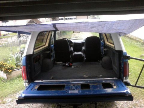 1991 Ford Bronco - View into the cargo area of a 1991 Ford Bronco, showing the interior and open tailgate.