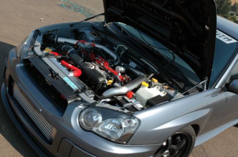 2004 Subaru Impreza - Engine bay of a 2004 Subaru Impreza, showing modifications like an intercooler and custom piping.