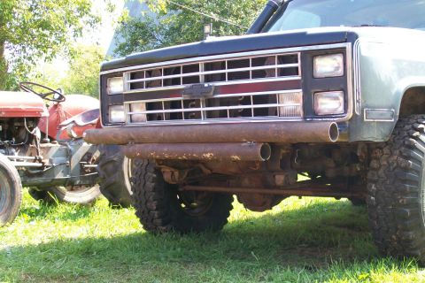 1988 Chevrolet Blazer - The front of a modified SUV is shown next to a tractor, with a custom pipe bumper and large tires.