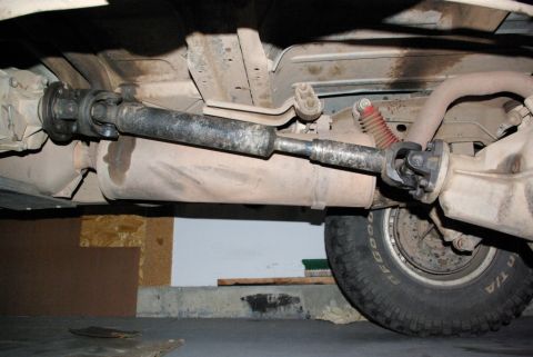 1995 Ford Bronco - Underside view of a 1995 Ford Bronco's driveshaft and rear differential, indicating signs of age and use.