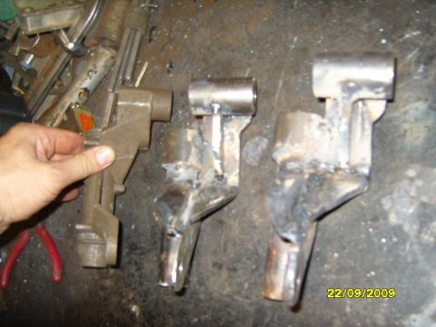 1989 Ford Bronco - A hand holds one of three metal parts displayed on a workbench, with a date stamp of 22/09/2009 visible.