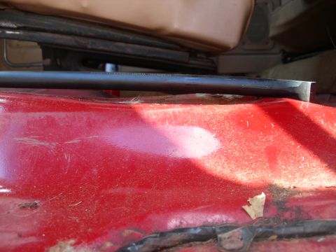 1984 Ford Bronco - The interior floor panel shows some wear and tear, with a black trim piece running across it.