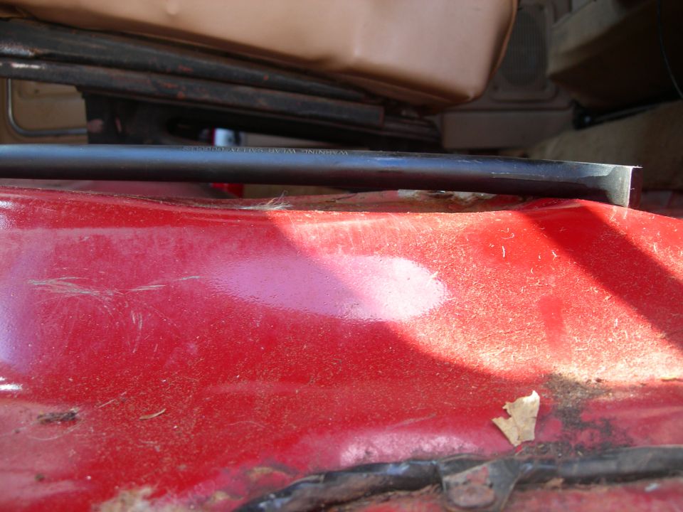 close-up of red interior floor panel with black trim piece above it