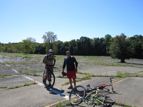 1981 Garelli Rally Sport - Two men and their bicycles are in an open area with trees in the background under a clear blue sky.