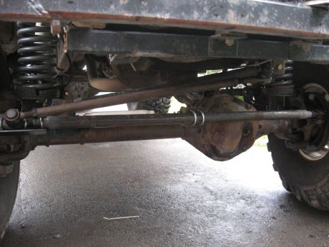 1990 Ford F-250 - The undercarriage of a vehicle is visible, focusing on the suspension and steering components.