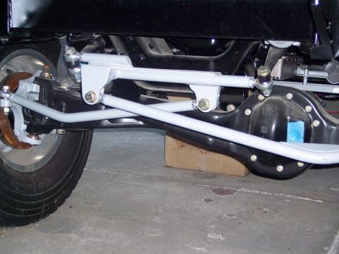 1984 Ford Bronco - Undercarriage view of a vehicle's steering and suspension system, with focus on the front axle and linkage.