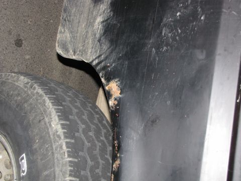 1993 Ford Bronco - Close-up view of a tire and the rusted fender of a vehicle.