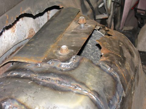 1993 Ford Bronco - This image shows a heavily rusted and welded metal panel, likely from the undercarriage of a vehicle. No specific year or model can be iden…