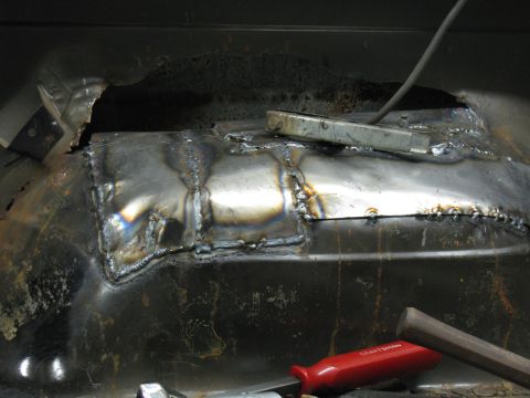 1993 Ford Bronco - A close-up view of a welded metal patch on a vehicle's undercarriage, indicating repair work.