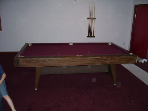 1991 Ford Bronco - A pool table is shown with a cue rack mounted on the wall behind it.