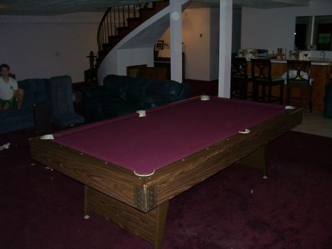 1991 Ford Bronco - A basement recreation area features a pool table, seating, and a bar area with stools.