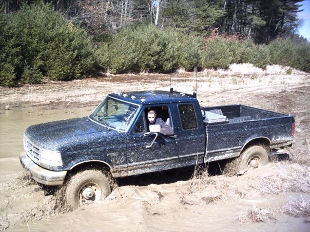 1989 Ford F-150 stuck in mud with driver looking out window