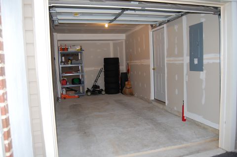 2002 BMW M3 - Interior view of a garage with storage, lawn equipment, and stacked tires.