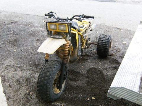 2000 Ford E350 - This yellow three-wheeled ATV features dual headlights and large, knobby tires, suggesting off-road capability.