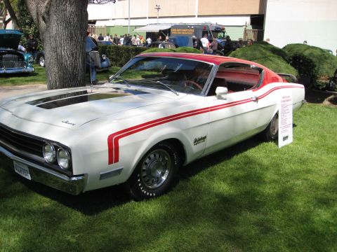 1956 Ford Fairlane - White 1969 Mercury Cougar Eliminator with red racing stripes and a red roof, parked on grass.