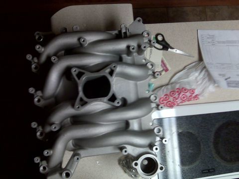 2001 Ford Crown Victoria - An intake manifold is shown on a countertop next to scissors and a bag of red gaskets.