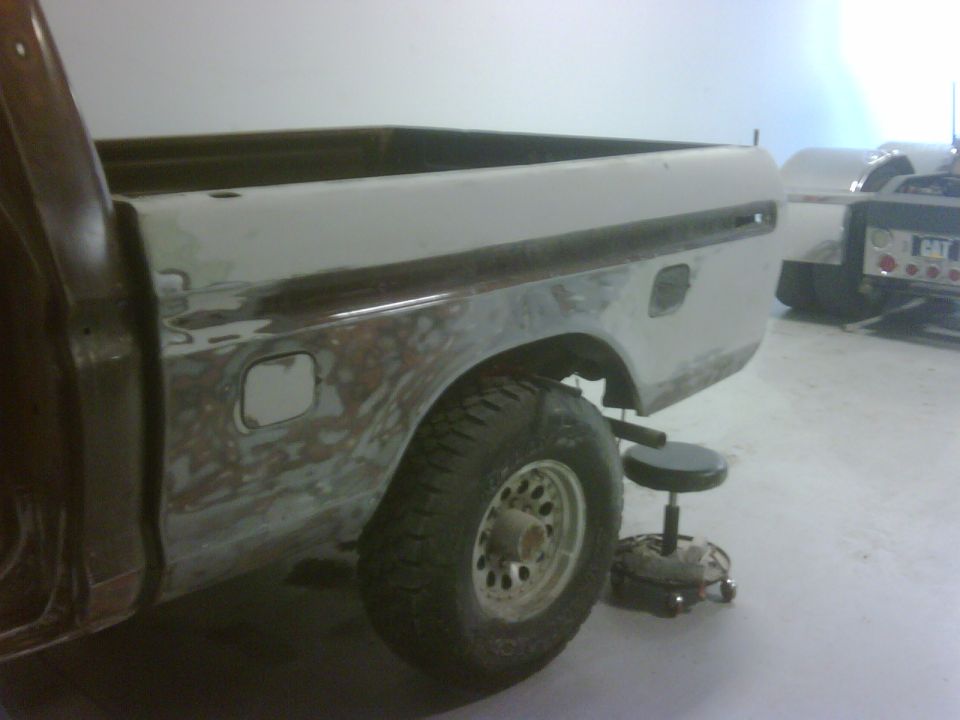 1979 Ford F-250 bed and rear fender, showing bodywork in progress. A stool is nearby